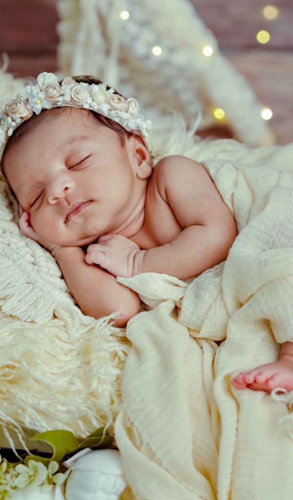Красивая новорожденная девушка с венком на голове 