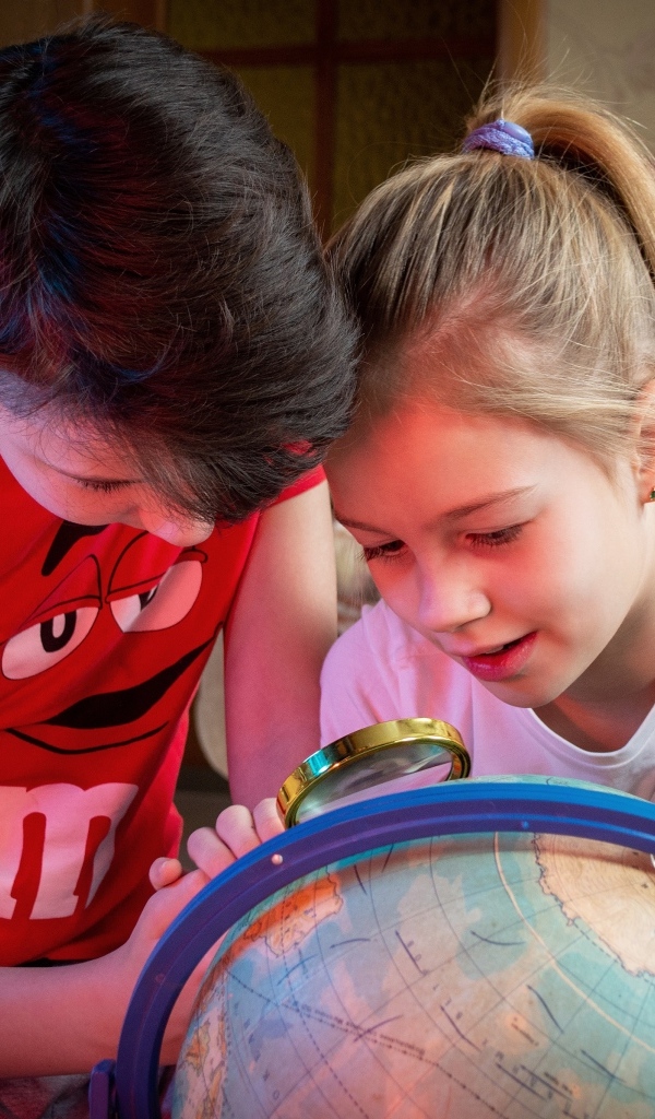 Дети школьники изучают глобус