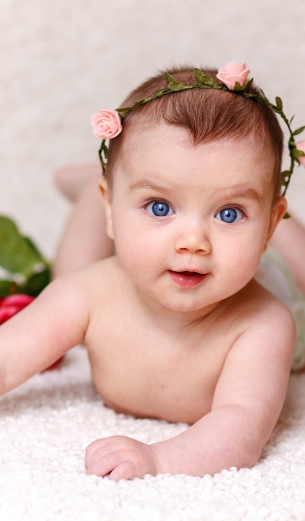 Милая голубоглазая малышка с цветами роз