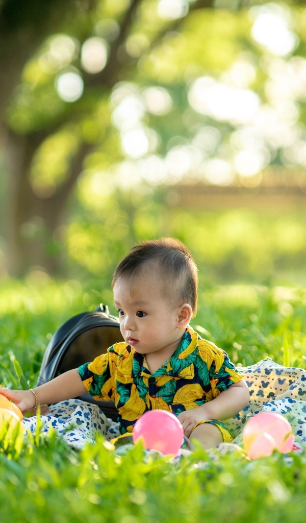 Милый маленький ребенок сидит на траве