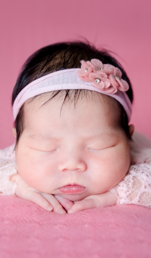 Милая спящая девочка азиатка с ободком на голове