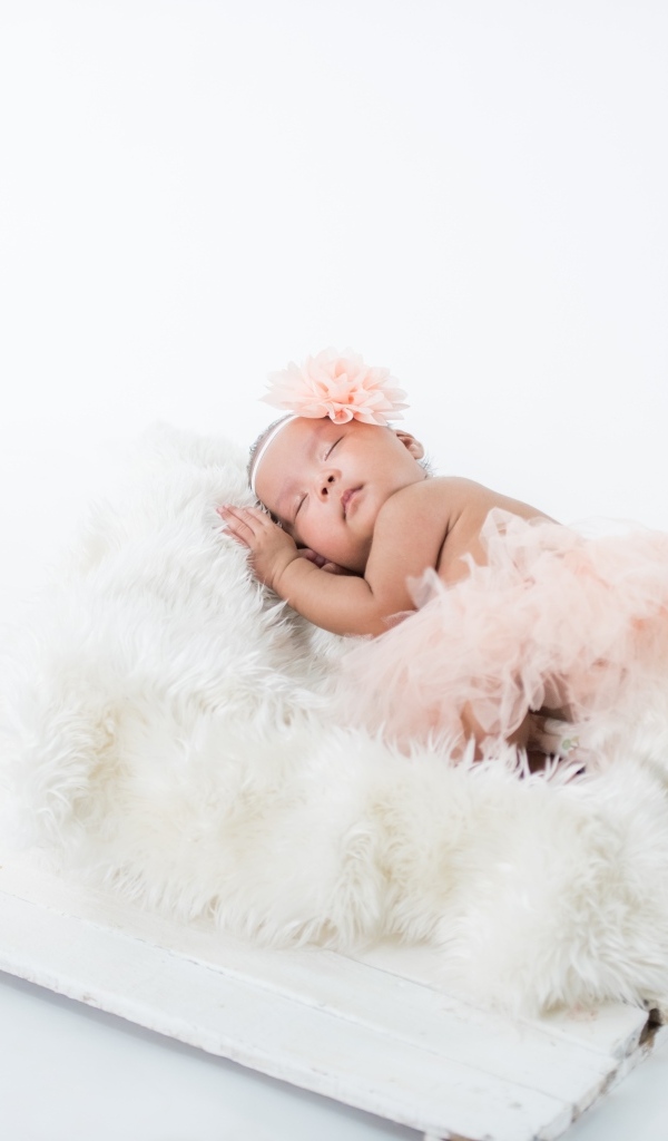 Милая спящая девочка в розовой юбке 