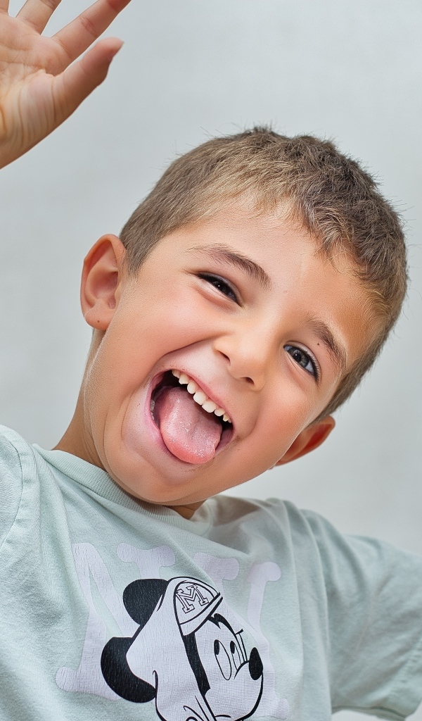 Смешной мальчик высунул язык