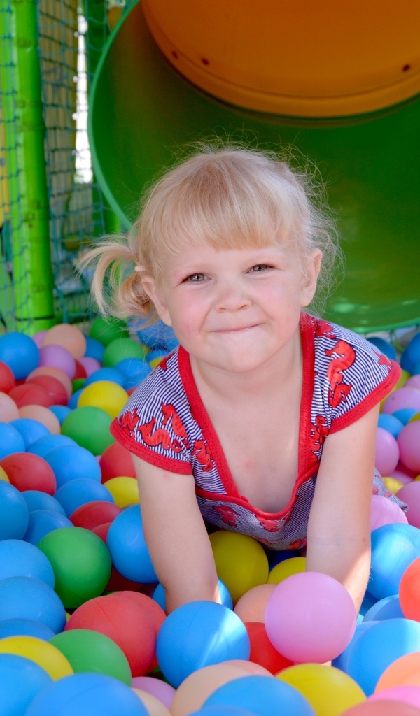 Забавная девочка играет в шариках