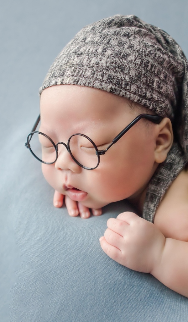 Забавный малыш в очках одет в серый костюм