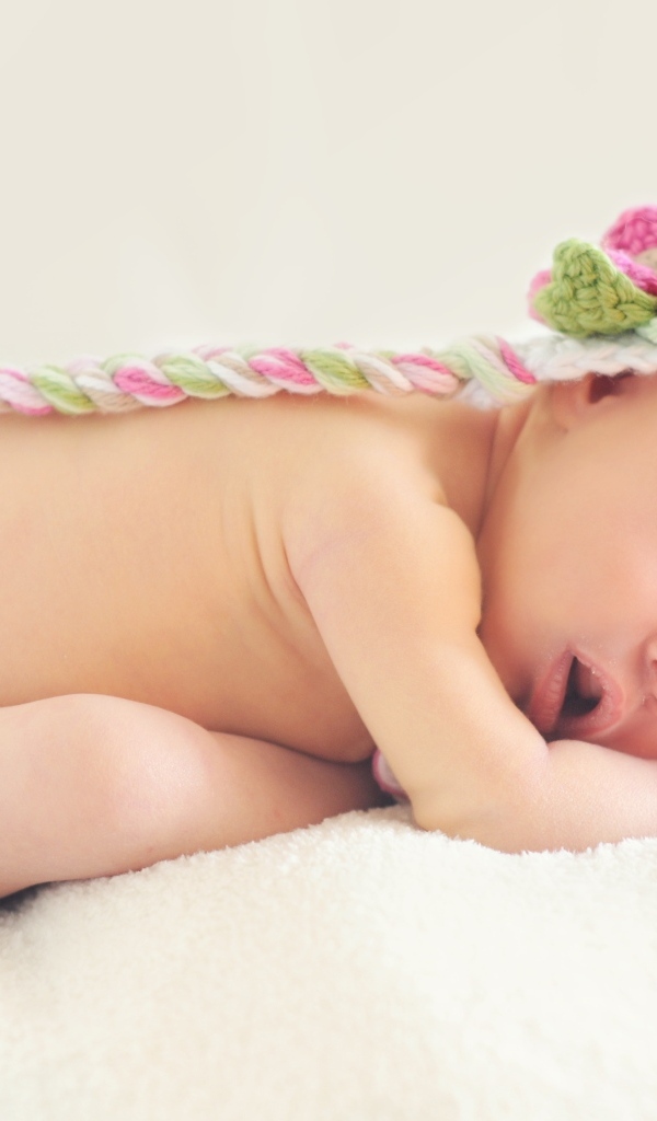 Нежный спящий ребенок в вязаной шапке 