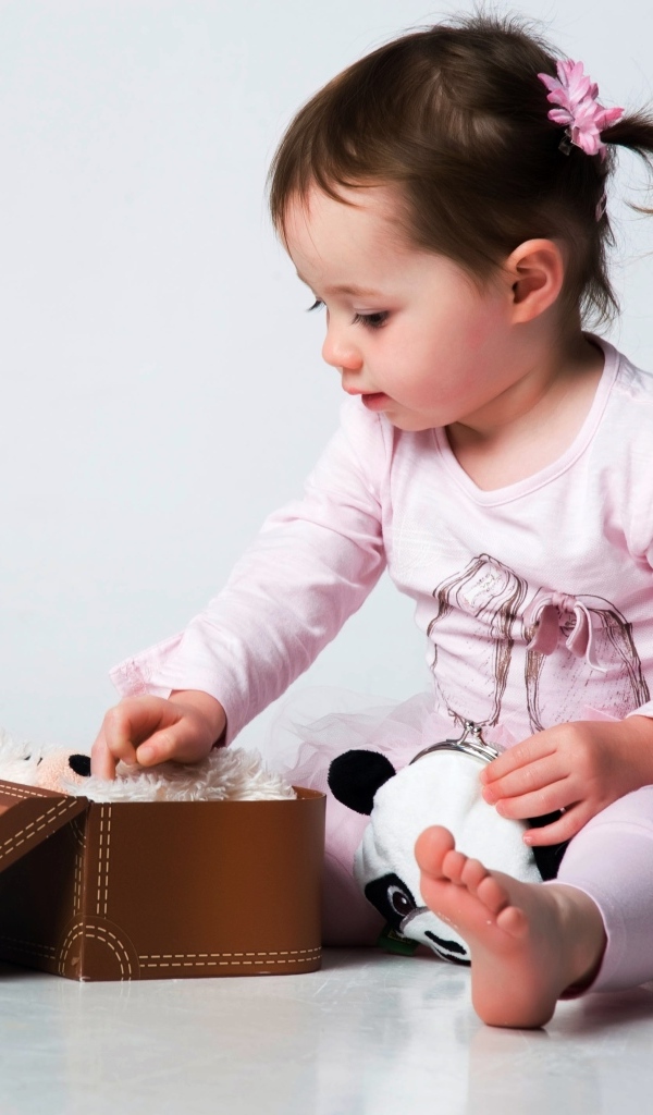 Девочка в розовом наряде с маленьким чемоданом