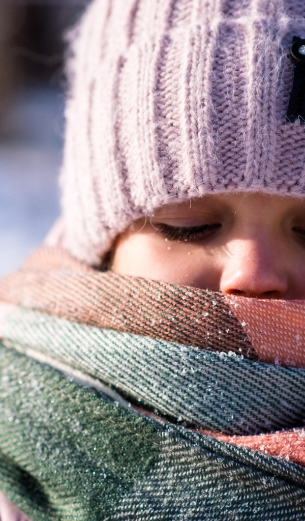 Девочка в теплой вязаной шапке зимой