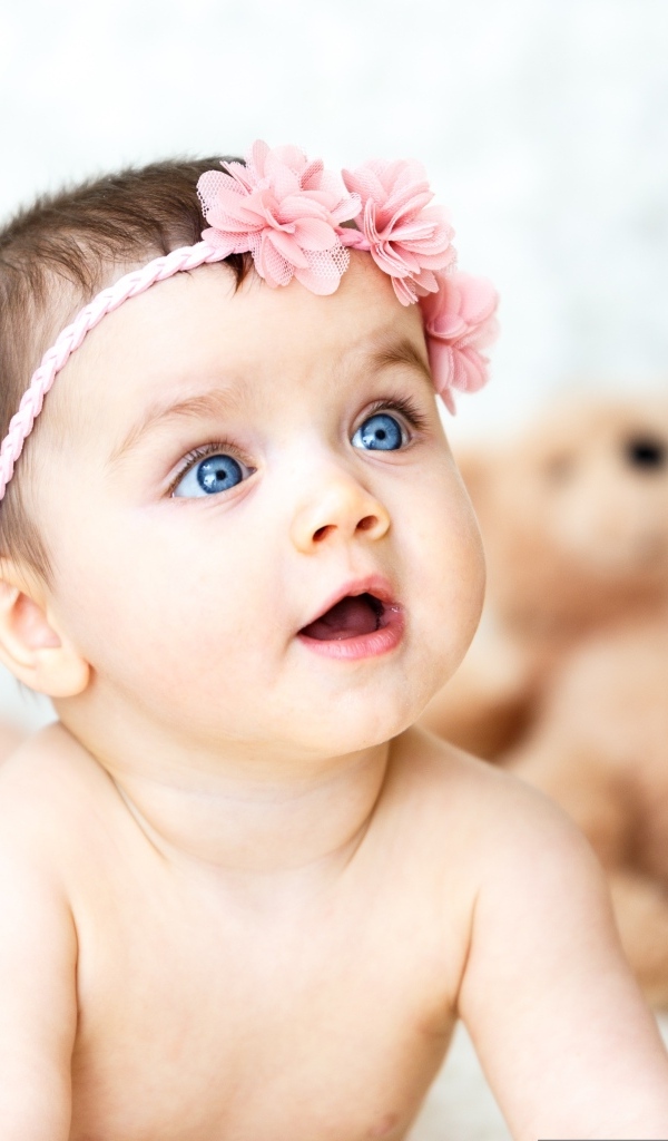 Девочка с голубыми глазами на фоне игрушек