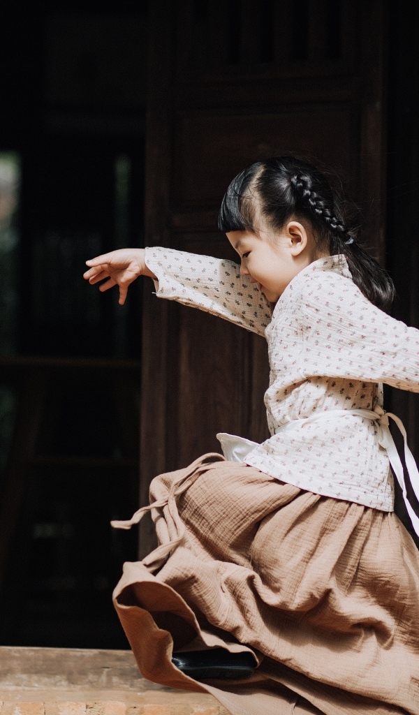 Маленькая девочка азиатка танцует