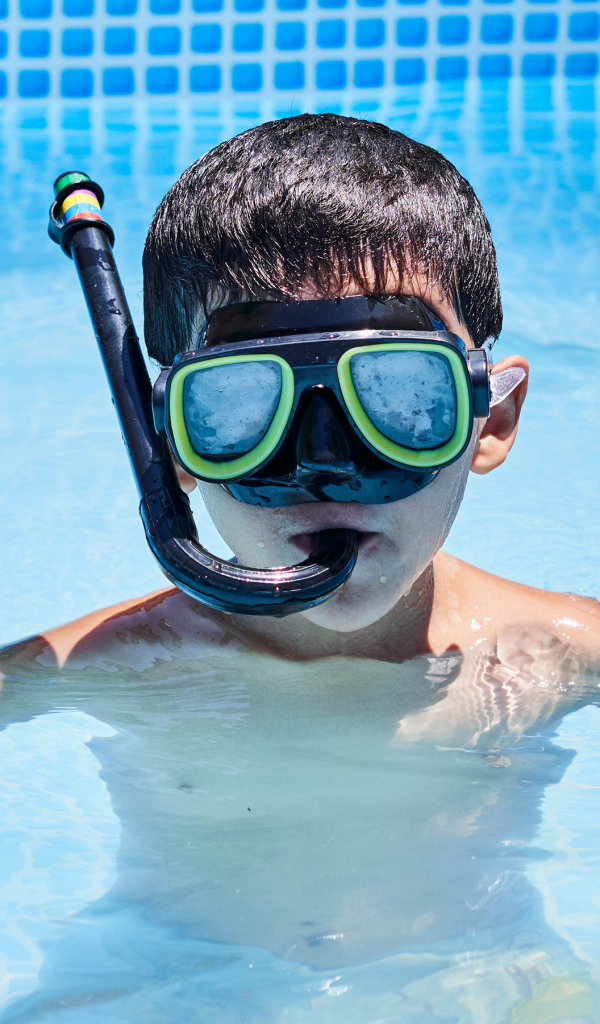 Маленький мальчик в маске в бассейне