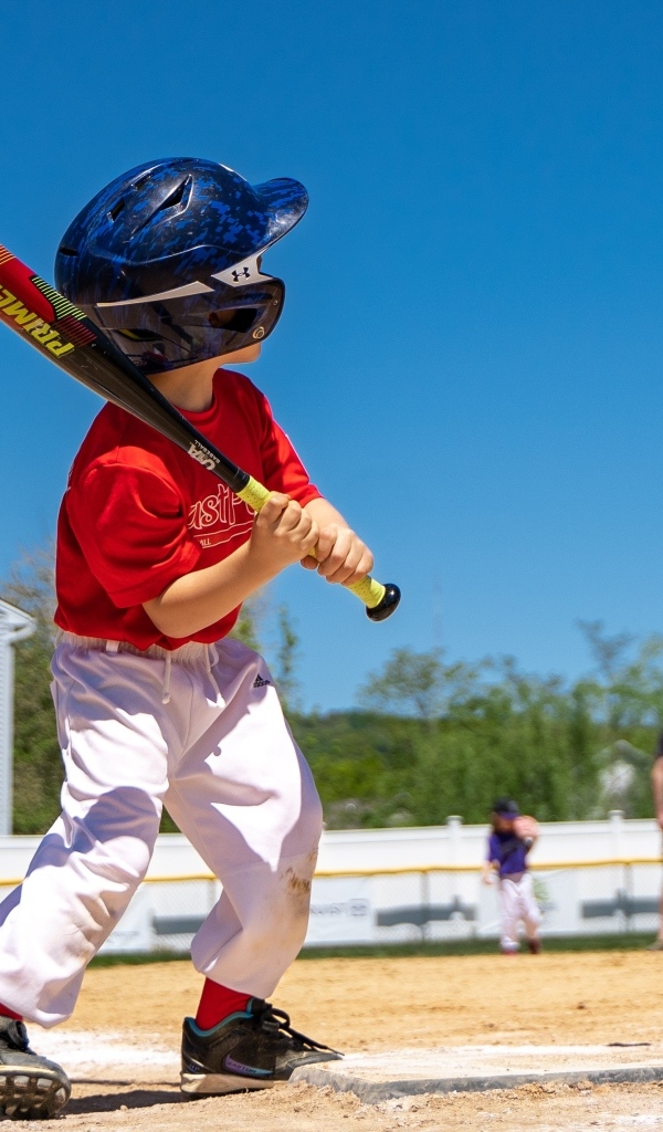 Маленький мальчик играет в бейсбол 