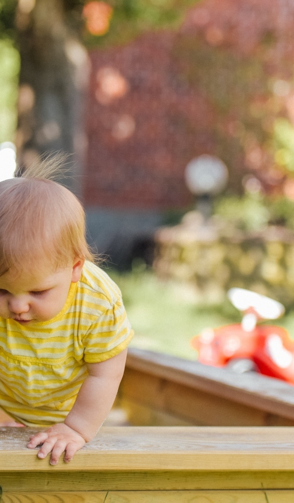 Маленький мальчик играет в песочнице