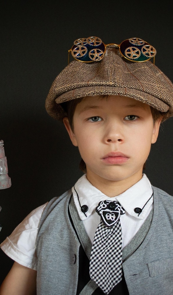 Маленький мальчик с игрушечным пистолетом на черном фоне