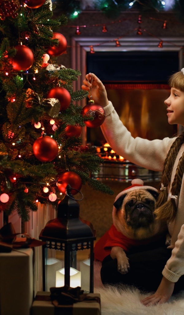 Маленькая девочка наряжает Рождественскую ель