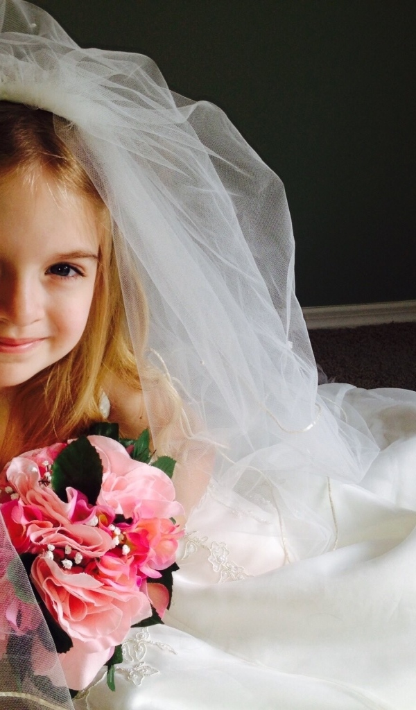 Маленькая девочка в костюме невесты с букетом