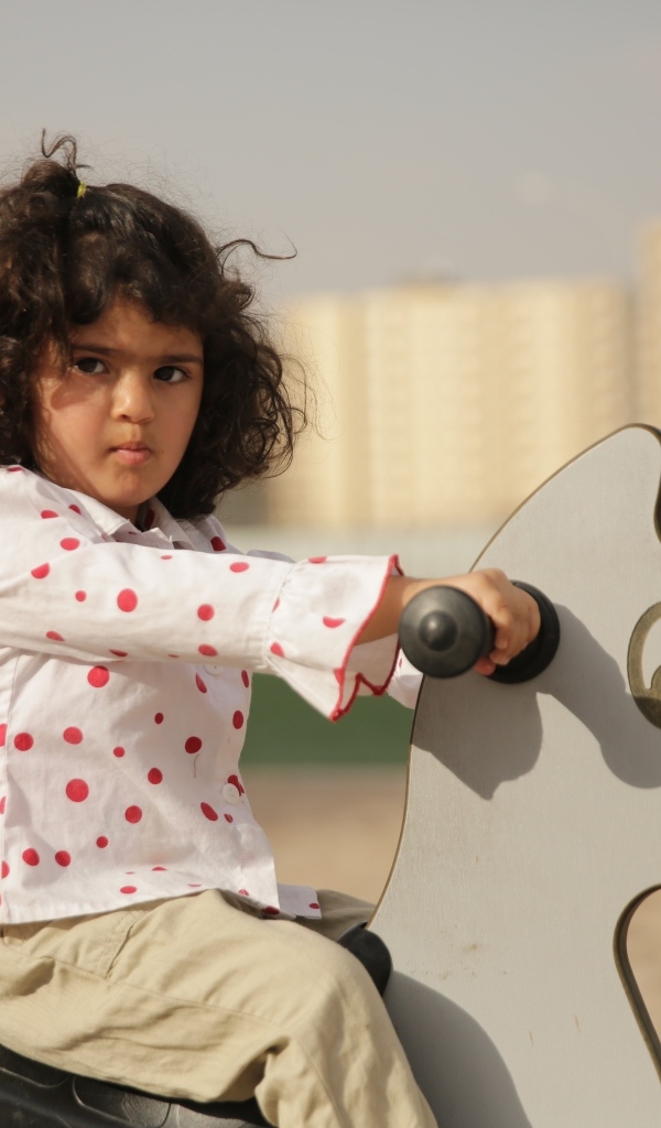 Маленькая девочка на деревянной лошади