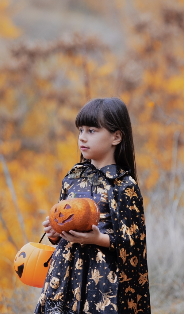 Маленькая девочка с тыквой в руках