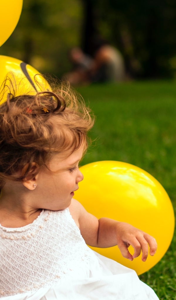 Маленькая девочка с желтыми шариками