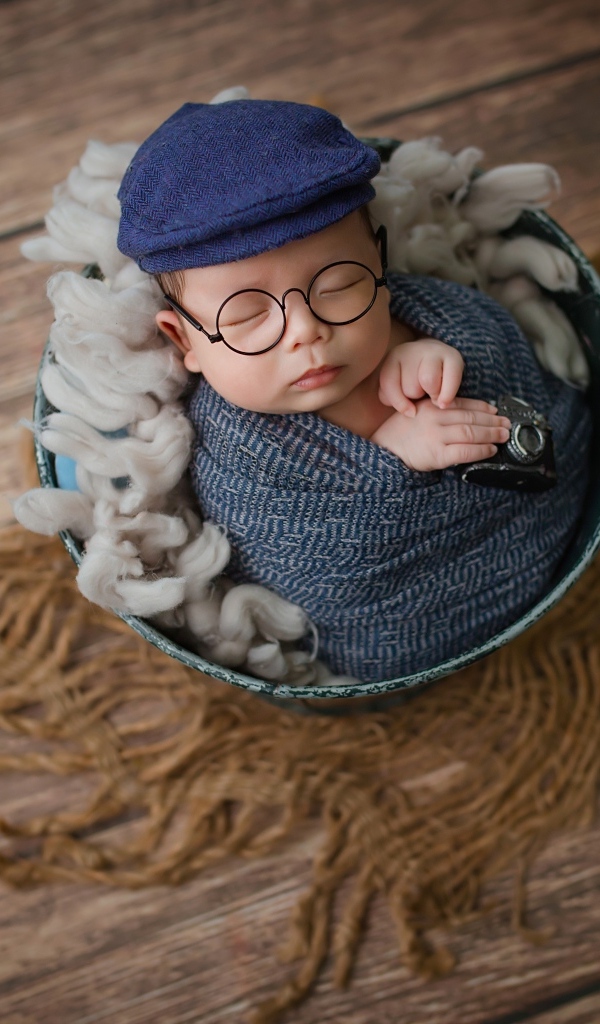 Маленький новорожденный ребенок в очках и кепке 