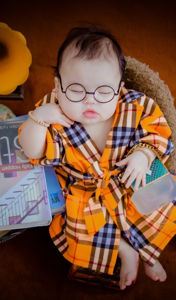 Маленький спящий ребенок в очках и халате