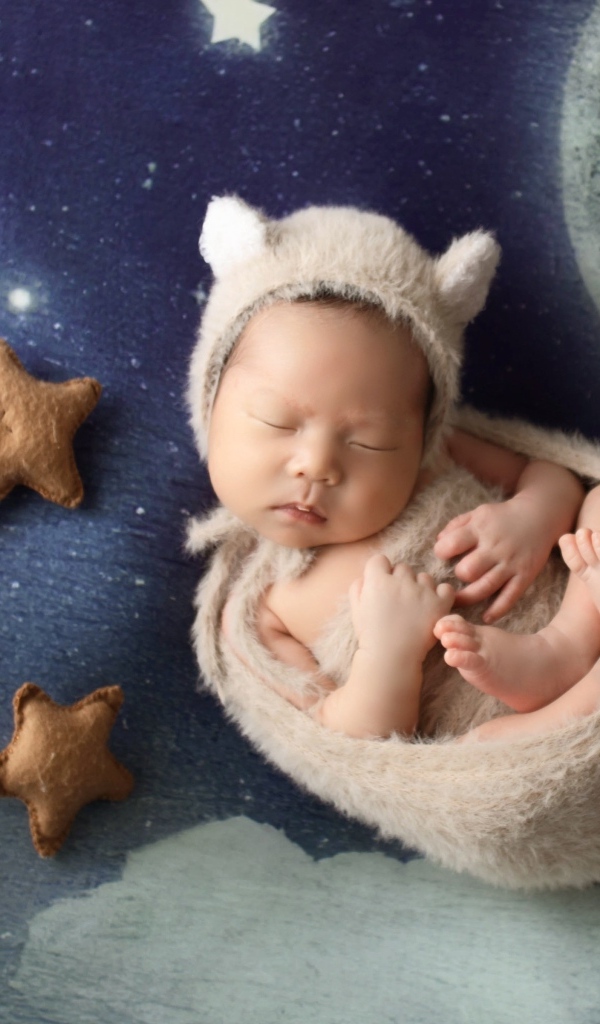 Маленький спящий грудной ребенок на синем покрывале