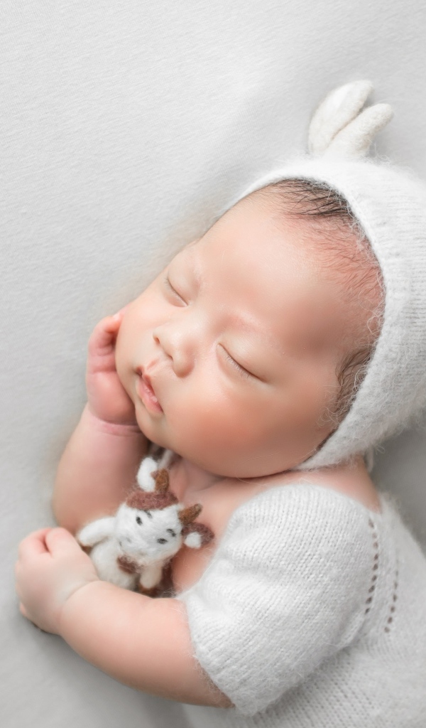 Маленький спящий малыш на сером фоне