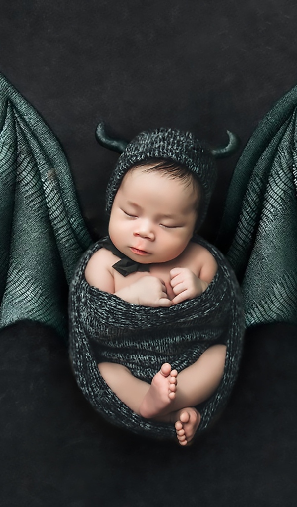 Маленький спящий ребенок с крыльями на Хэллоуин