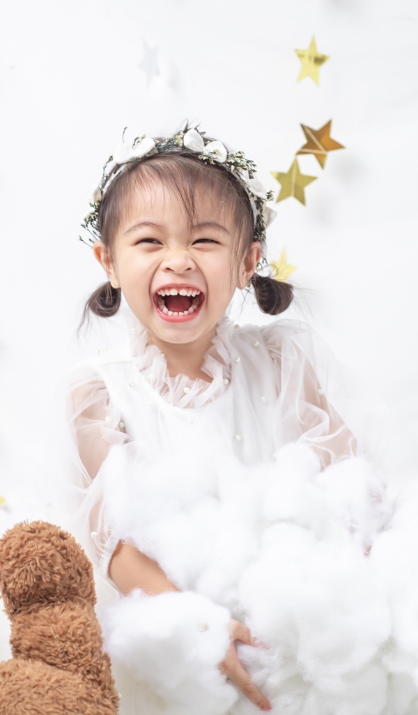 Маленькая улыбающаяся девочка азиатка в белом платье