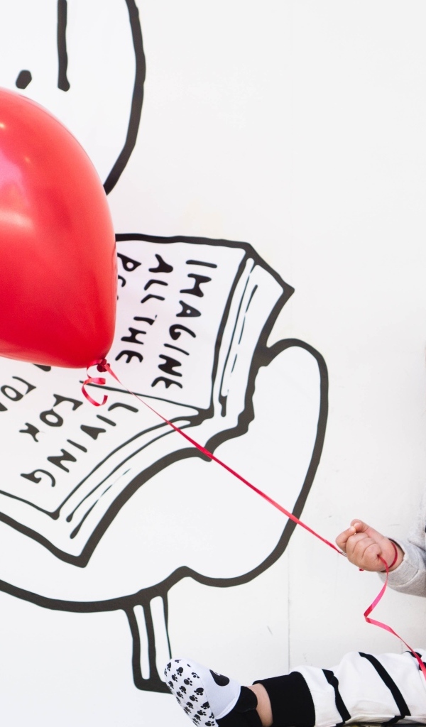 Маленький улыбающийся мальчик с шариком в руках