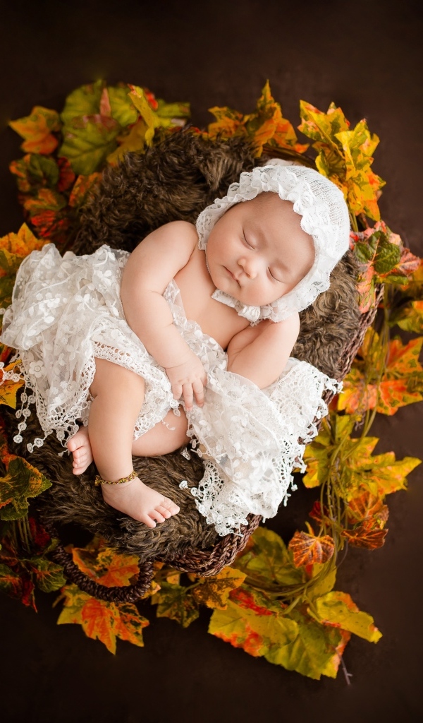 Новорожденная девочка в колыбели в белом костюме