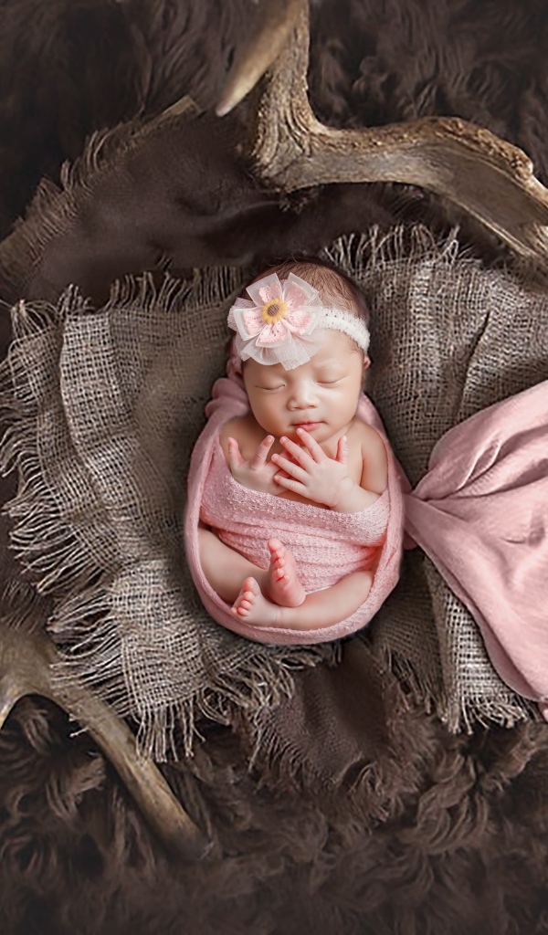 Новорожденная девочка на покрывале с рогами