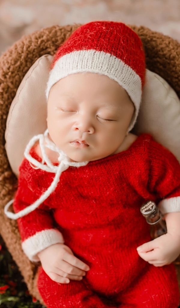 Новорожденный малыш в красном вязаном костюме