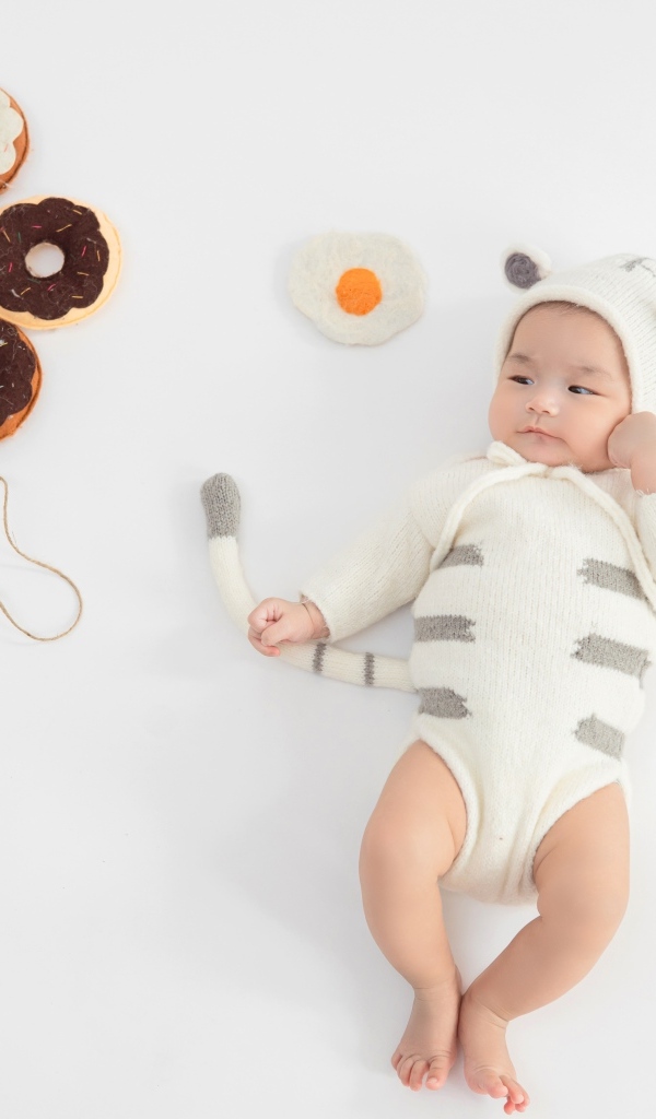 Новорожденный ребенок в костюме с пончиками