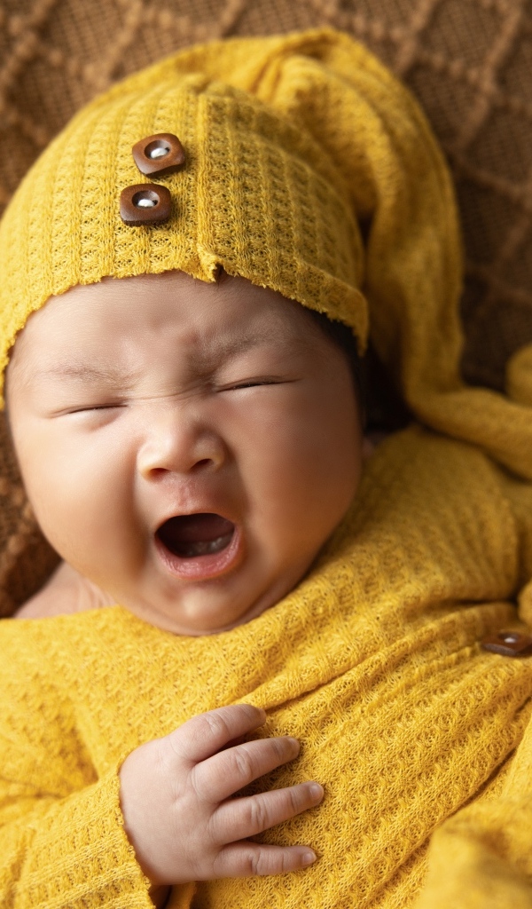 Новорожденный ребенок зевает во сне