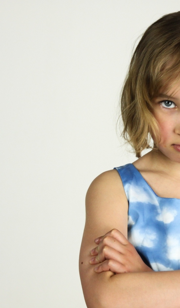 Серьезная девочка на сером фоне