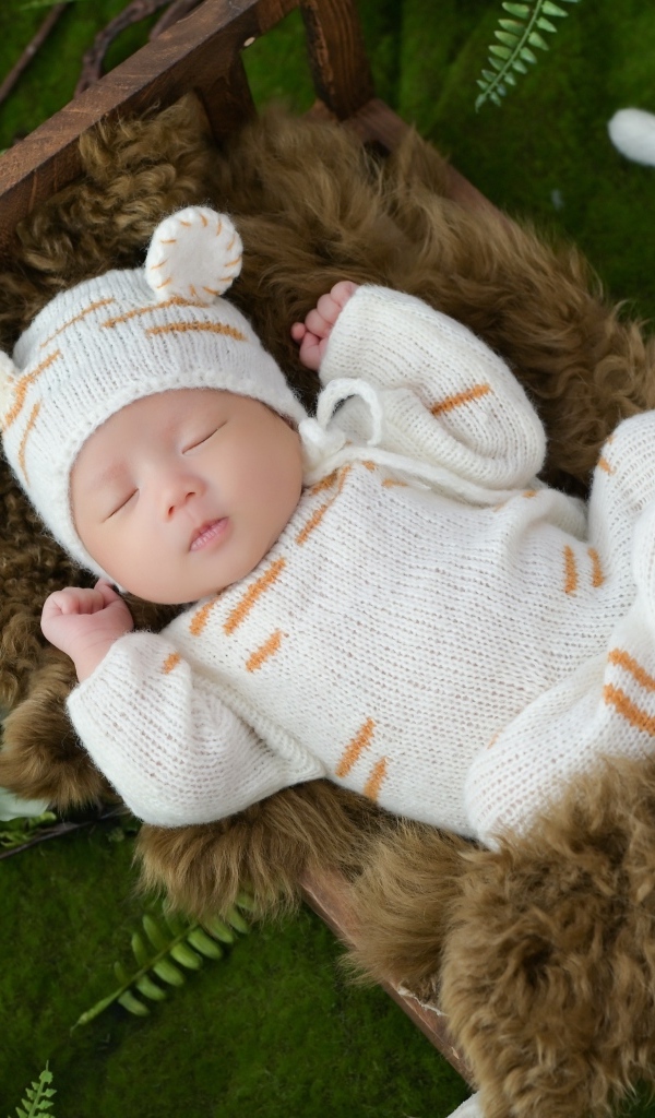 Спящий новорожденный ребенок в костюме тигренка