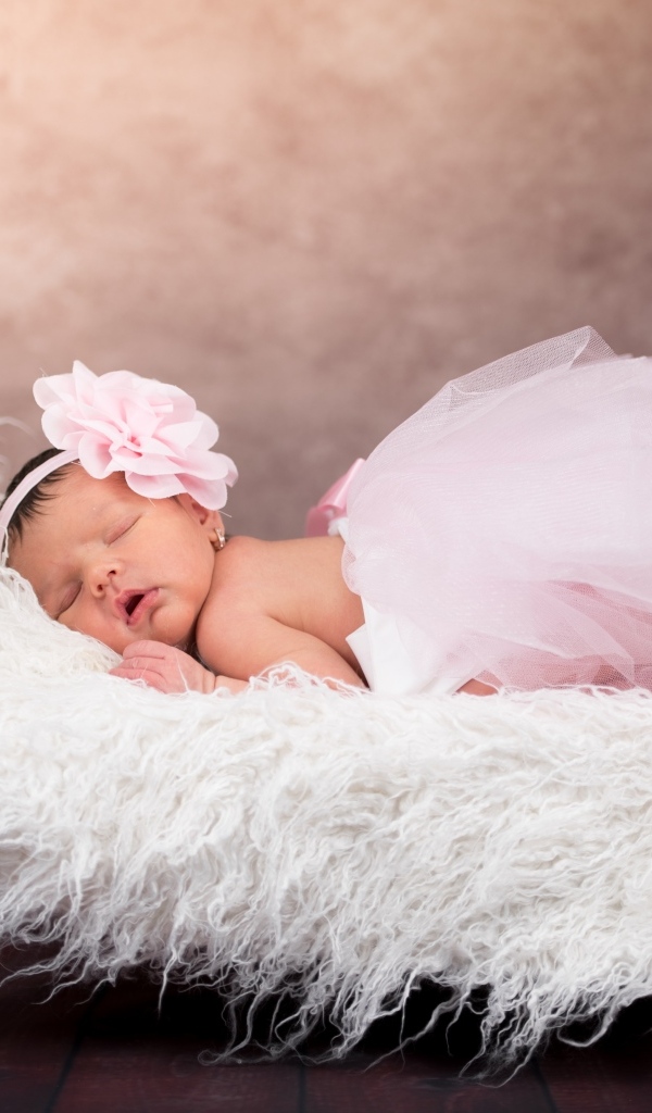 Спящая новорожденная девочка в пышной юбке