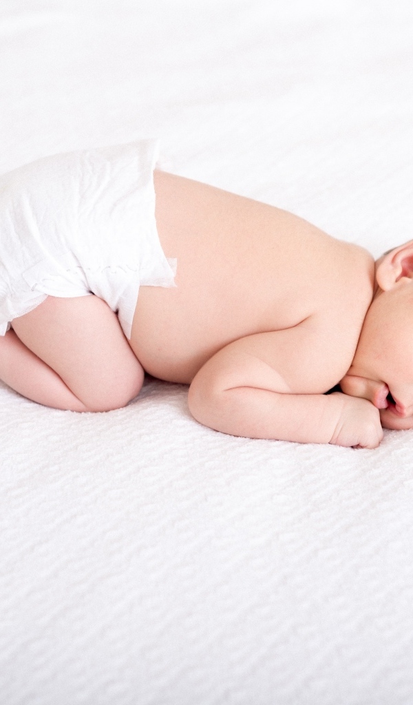 Спящий новорожденный ребенок в памперсе