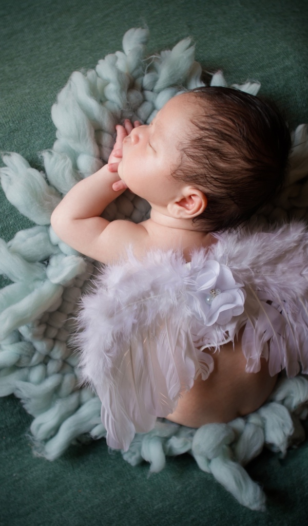 Спящий новорожденный малыш с крыльями ангела 