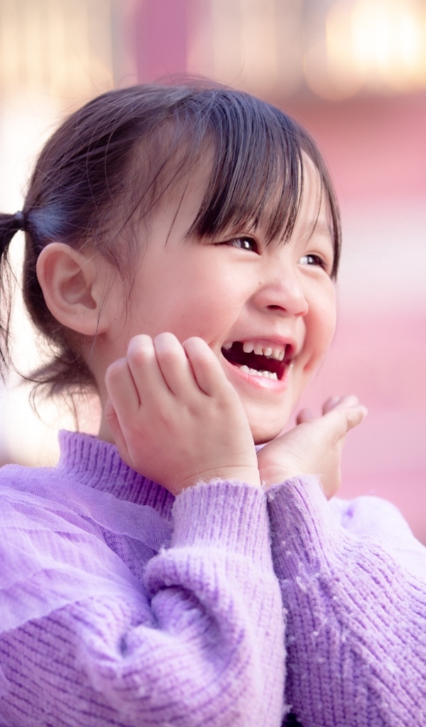 Улыбающаяся маленькая девочка азиатка в свитере