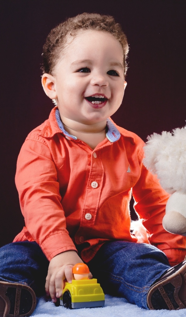 Улыбающийся мальчик с игрушечным медведем