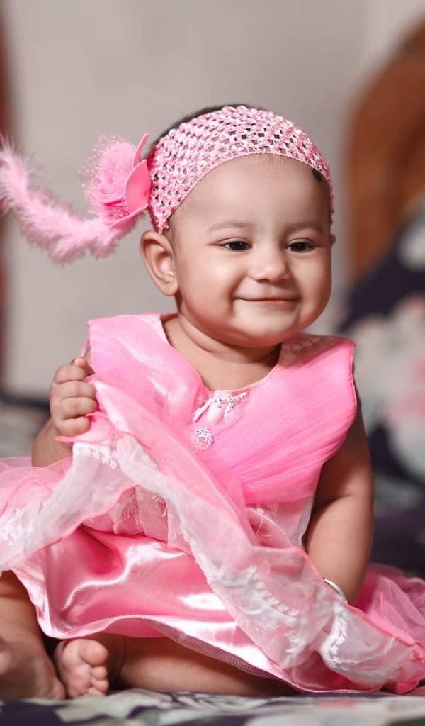 Улыбающаяся девочка в красивом розовом платье