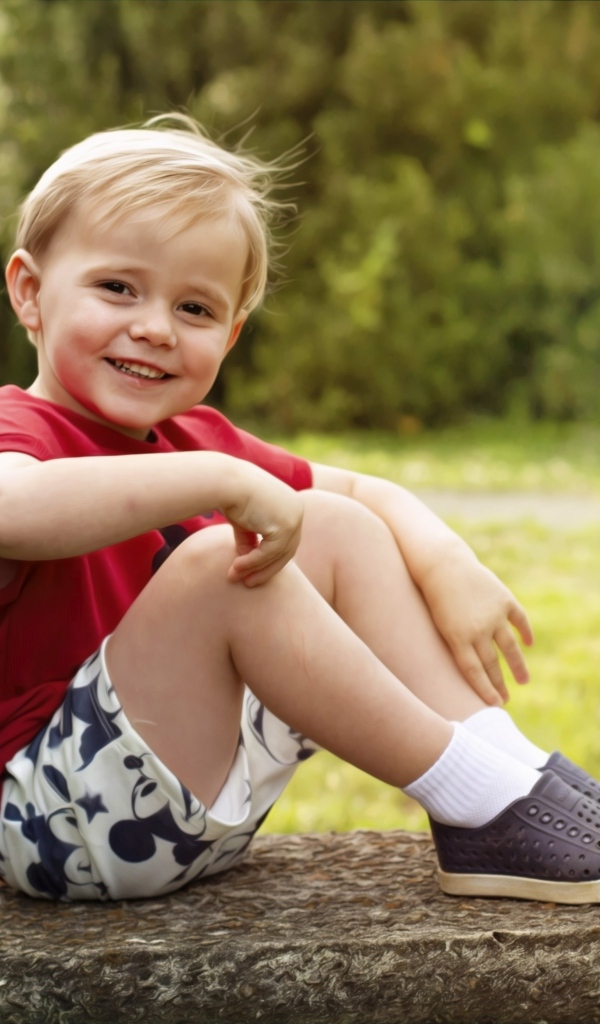 Улыбающийся маленький мальчик в красной футболке