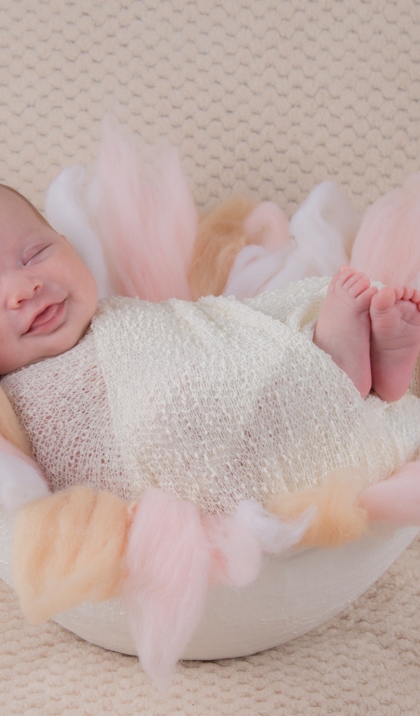 Улыбающийся спящий новорожденный малыш