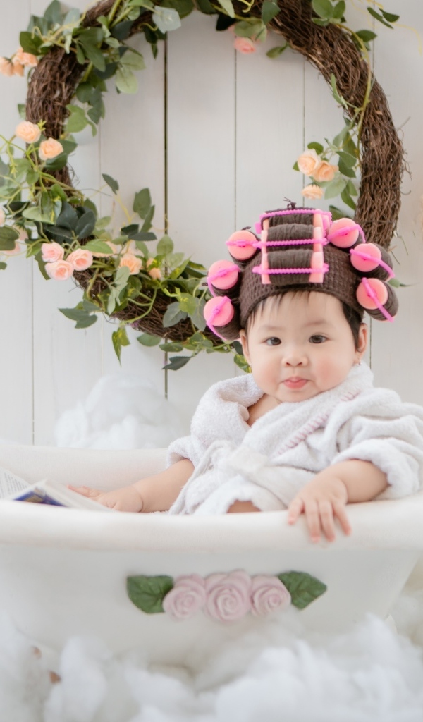 Ребенок сидит в ванной в халате