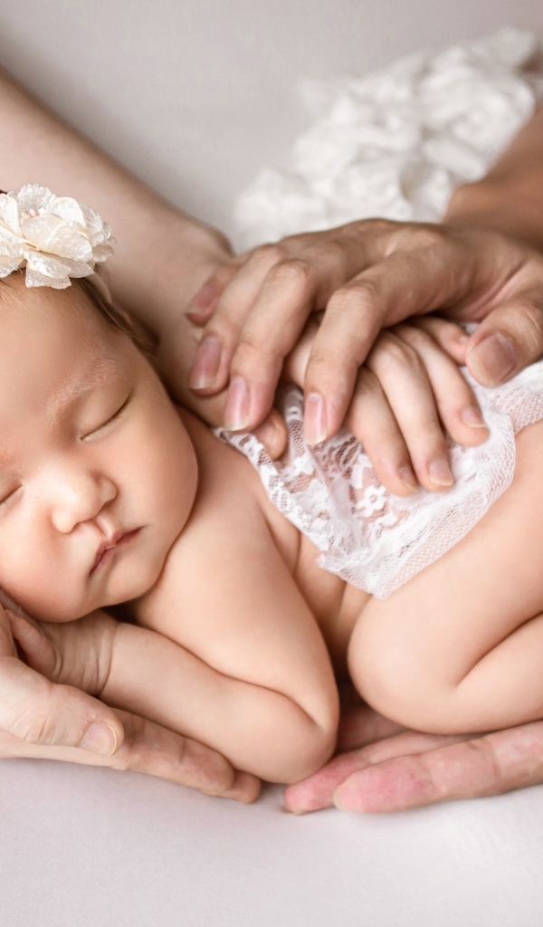 Руки родителей оберегают спящего малыша