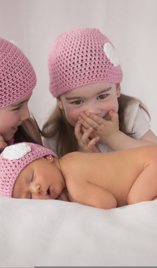 Три маленькие девочки в вязаных шапках