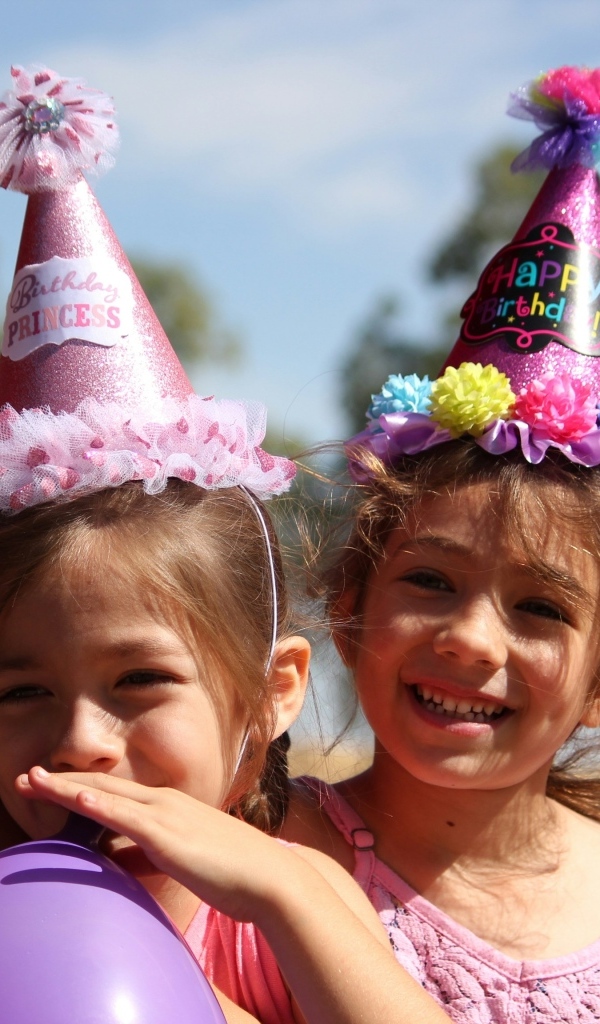 Две маленькие веселые девочки отмечают день рождения