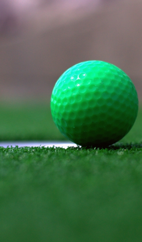 Зеленый мяч для игры в гольф на траве